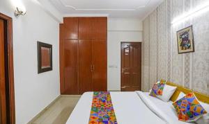um quarto com uma cama e um armário de madeira em FabExpress AP International em Noida