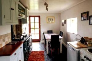 een keuken met een aanrecht en een tafel. bij Cosy 3 Bed Cottage near 3 Peaks - Log Burner & Aga in High Bentham