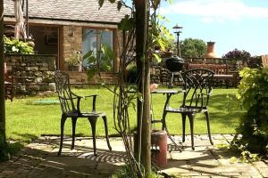 twee stoelen en een tafel in de tuin bij Cosy 3 Bed Cottage near 3 Peaks - Log Burner & Aga in High Bentham