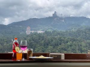 a table with a plate of food and a glass of wine at Genting View Resort Duplex Penthouse 5R4B 17pax by Jen.dehome in Genting Highlands