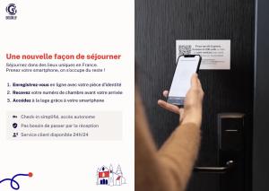 een persoon met een mobiele telefoon voor een deur bij La Loge Gogaille - Préfecture - Accès autonome in Limoges