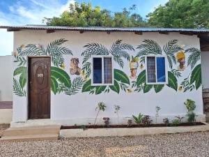 a house with a mural on the side of it at wannas house in Nungwi