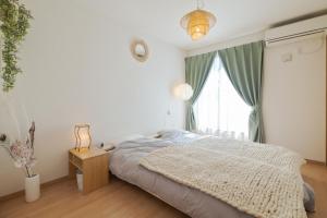 a white bedroom with a bed and a window at 【１日１組・１棟貸切】春日井駅徒歩10分！老舗ワイン店「ふじみ家」提携 ペット歓迎 in Kasugai