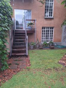 a staircase leading up to a house with a door at Die Eend in Centurion