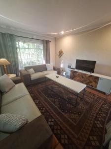 a living room with a couch and a table at Die Eend in Centurion