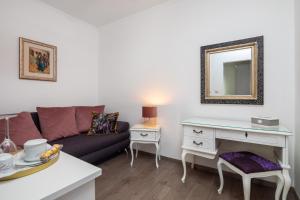 een woonkamer met een bank en een spiegel bij Romantic Luxury Rooms in Split
