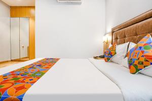 a bedroom with a large bed with colorful pillows at FabHotel Zara Grand in Mumbai