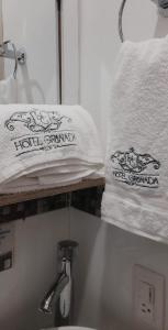 uma prateleira com toalhas e um lavatório na casa de banho em Hotel Granada Loft em Cali