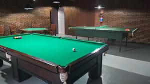a pool table in a room with two tables at Hotel Sambura in Imbé