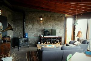 sala de estar con 2 sofás y TV en Mystic stone house at the ancient city of Assos, en Behramkale