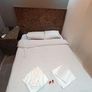 ein Bett mit weißer Bettwäsche und zwei Kissen darauf in der Unterkunft Reyna otel taksim in Istanbul