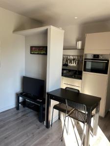 una pequeña cocina con mesa negra y sillas en Studio indépendant en Vence