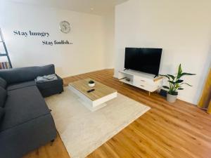 uma sala de estar com um sofá e uma televisão de ecrã plano em modern * gemütlich * Nespresso * Terrasse * Netflix em Duisburgo