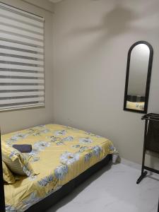 um quarto com uma cama com um espelho e um espelho em AMDH Homestay em Kampong Kemaman