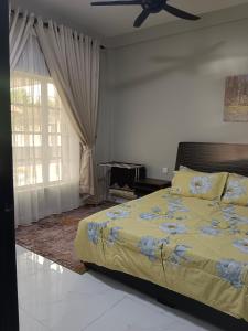 um quarto com uma cama e uma ventoinha de tecto em AMDH Homestay em Kampong Kemaman