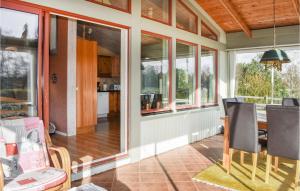 Munka-LjungbyにあるStunning Home In Munka-ljungby With 3 Bedroomsの窓のあるダイニングルーム(テーブル、椅子付)