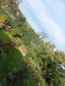 une colline herbeuse avec une maison au sommet dans l'établissement hoteliving Düsseldorf Airport, à Ratingen