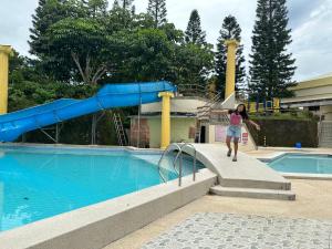 a woman standing on a slide next to a swimming pool at Tagaytay Sweet Home in Tagaytay