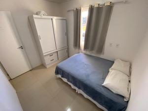 a small bedroom with a bed and a window at Lar de piatã 2 quartos in Salvador