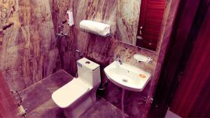 a bathroom with a white toilet and a sink at The MadhuNandan in Rāmnagar