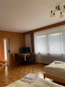 a bedroom with two beds and a desk with a television at Ruhige 4 Zimmer EG-Wohnung Z1 in Königsbronn