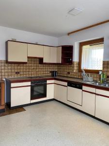 Una cocina vacía con gabinetes blancos y una ventana. en Ruhige 4 Zimmer EG-Wohnung Z1, en Königsbronn