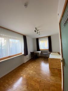an empty room with a desk and two windows at Ruhige 4 Zimmer EG-Wohnung Z1 in Königsbronn