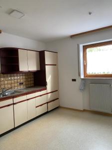 a kitchen with white cabinets and a window at Ruhige 4 Zimmer EG-Wohnung Z1 in Königsbronn