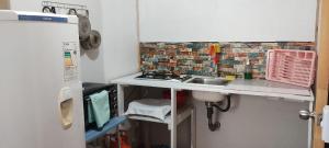 a small kitchen with a sink and a brick wall at DepartamentoVista Queule in Toltén