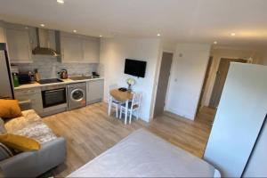 a kitchen and living room with a couch and a table at Shoreditch / Brick Lane - Studio in London