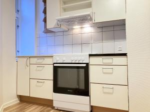 a white kitchen with a stove and a microwave at 2 Bedroom Apartment In Odense City Center in Odense