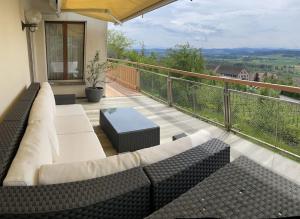 a patio with couches and tables on a balcony at Wohlfühl-Haus mit Panoramablick in Oberneuforn