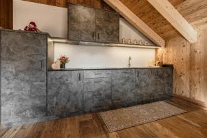 a kitchen with a concrete wall and a sink at FARM CHALET JUSCIARA in Badia