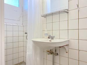 a bathroom with a white sink and a mirror at One Bedroom Apartment In Valby, Langagervej 64, in Copenhagen