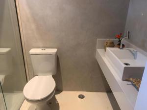 Pousada Manacá Exclusive Suítes في ريفاينا: حمام به مرحاض أبيض ومغسلة