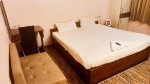 um quarto com uma cama com um computador portátil em hotel darbar international em Gaya