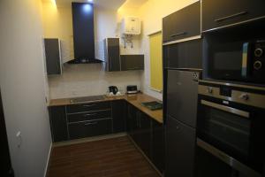a kitchen with black cabinets and a black refrigerator at Gulberg Suites in Lahore