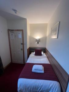 a hotel room with a bed with a pillow on it at Holborn Hotel in Thurso