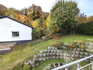um jardim com uma parede de retenção e uma casa em K-TOWN GREEN Studio Apartment em Kaiserslautern