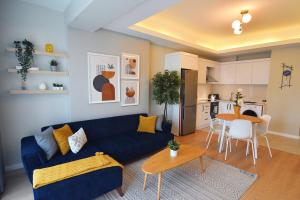 un soggiorno con divano blu e una cucina di Cozy 1br Apt Perfect Blend Of Comfort & Style a Istanbul