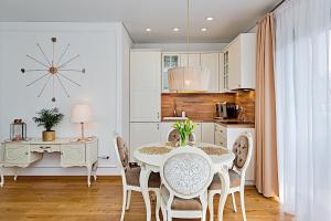 a kitchen and dining room with a table and chairs at Gintarinė KOPA in Palanga