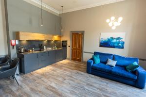 a living room with a blue couch and a kitchen at MONO Suites NEW TOWN in Edinburgh +15 photos