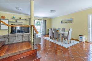 ein Esszimmer und ein Wohnzimmer mit einem Tisch und Stühlen in der Unterkunft flowers island house 4 in Caniço