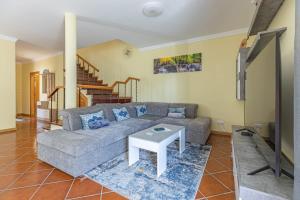 ein Wohnzimmer mit einem Sofa und einem Tisch in der Unterkunft flowers island house 4 in Caniço