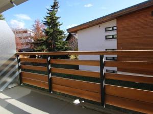 una recinzione di legno di fronte a una casa di Appartement Huez, 1 pièce, 4 personnes - FR-1-405-67 a LʼAlpe-dʼHuez