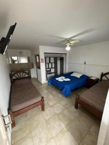 a bedroom with two beds and a blue bed at Hotel 4 Ases in Embalse
