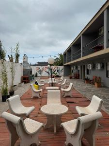 a row of white chairs and tables on a patio at Hotel 4 Ases in Embalse