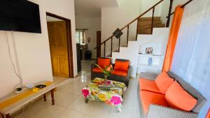 a living room with a couch and a table and stairs at Josies Cottage in Beau Vallon