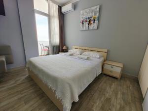 Un dormitorio con una cama grande y una ventana en Queen Tamara Apartments, en Makhinjauri