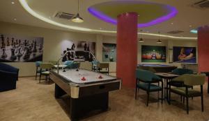 una sala de juegos con mesa de billar y pelotas de ping pong en Rajhans Belliza Aashiana, en Surat
